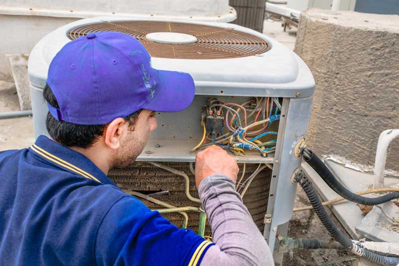 A C Expert Servicing An A C Unit